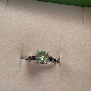 2.20 carat Round Blue Moissanite center surrounded by Blue Sapphires.. size 6.